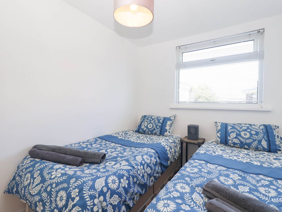 A bedroom with two beds and a bedside table at 122 Norton Park in Dartmouth