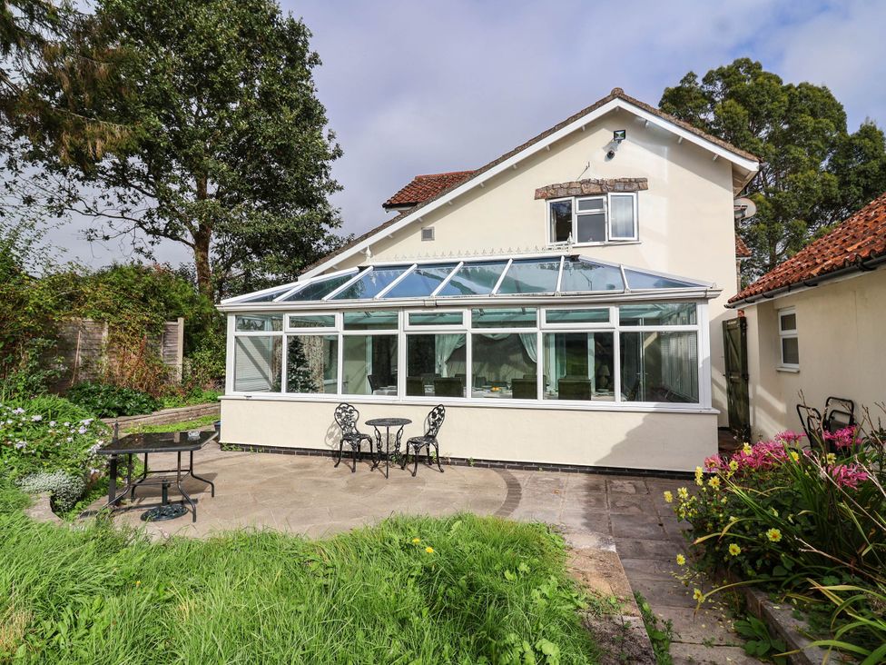 A conservatory with a garden table and chairs at Herriotts Bridge Cottage in Bristol