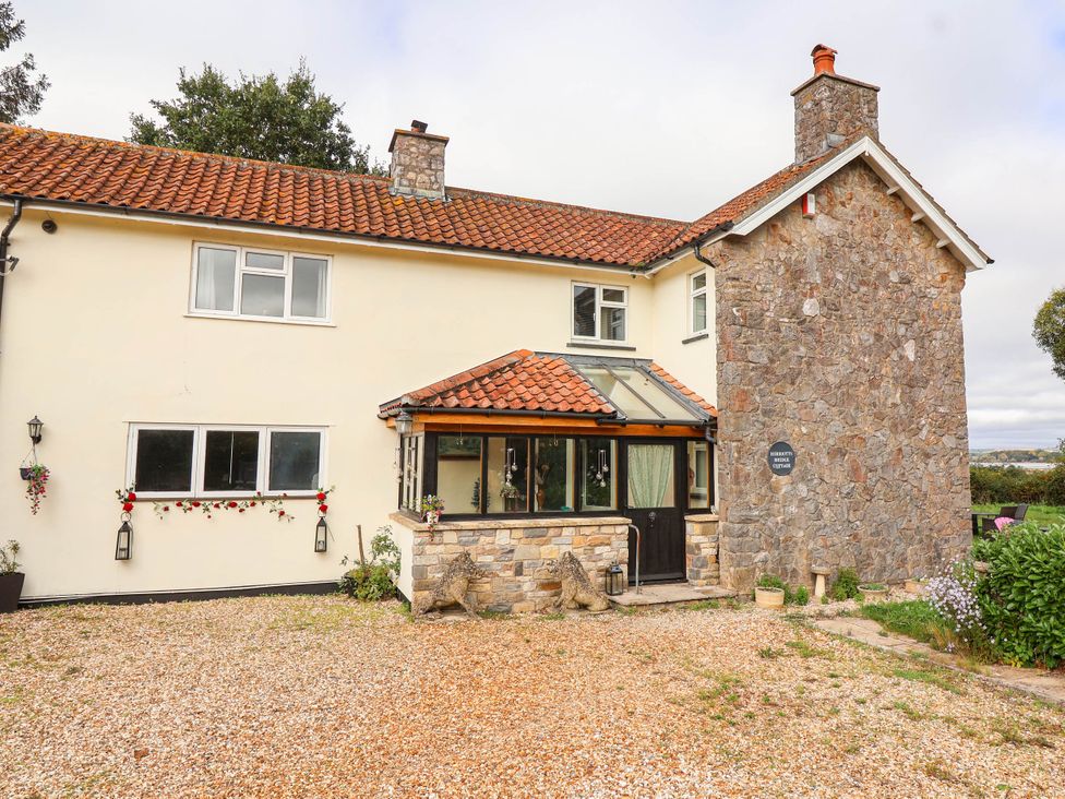 A house with stone features and a gravel pathway at Herriotts Bridge Cottage in Bristol