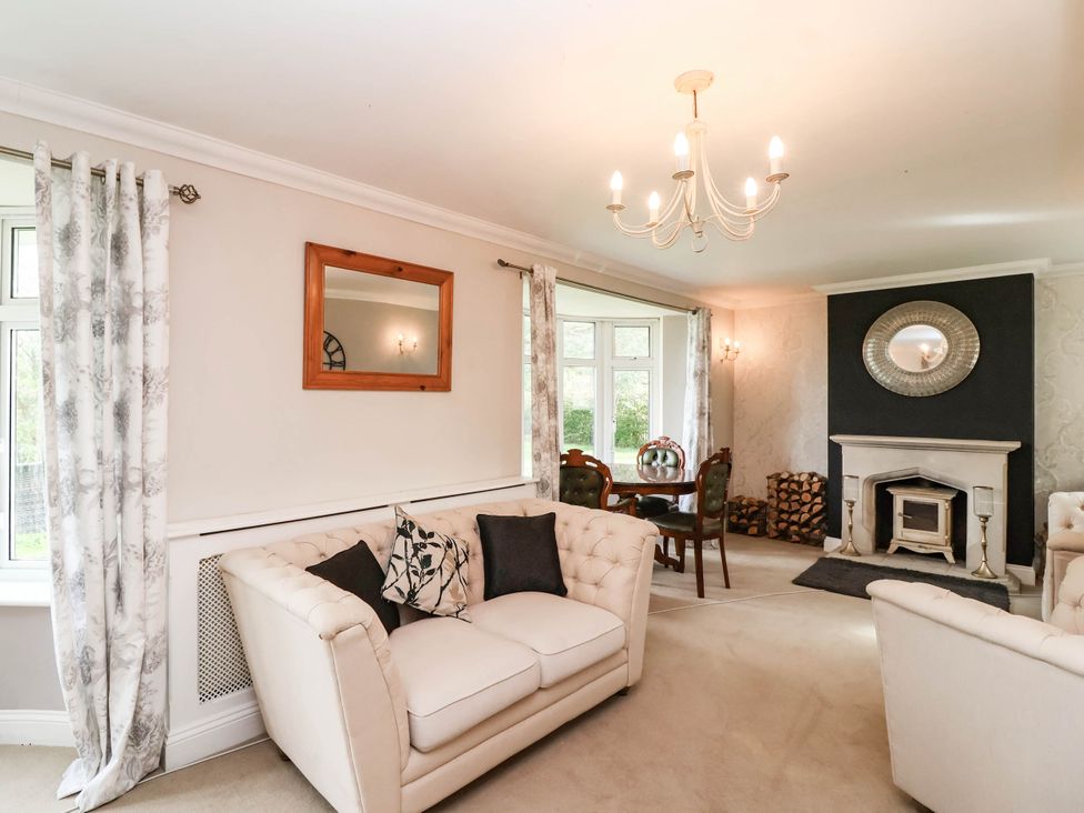 A living room with a chandelier and fireplace at Herriotts Bridge Cottage in Bristol
