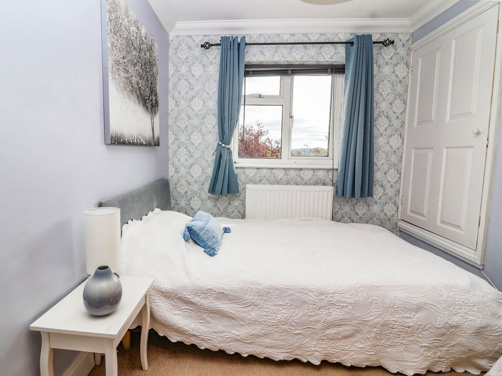 A bedroom with a bed and window at Herriotts Bridge Cottage in Bristol