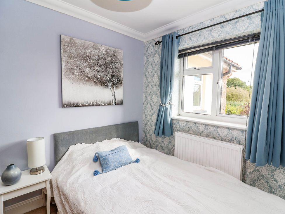 A bedroom with a bed and window at Herriotts Bridge Cottage in Bristol