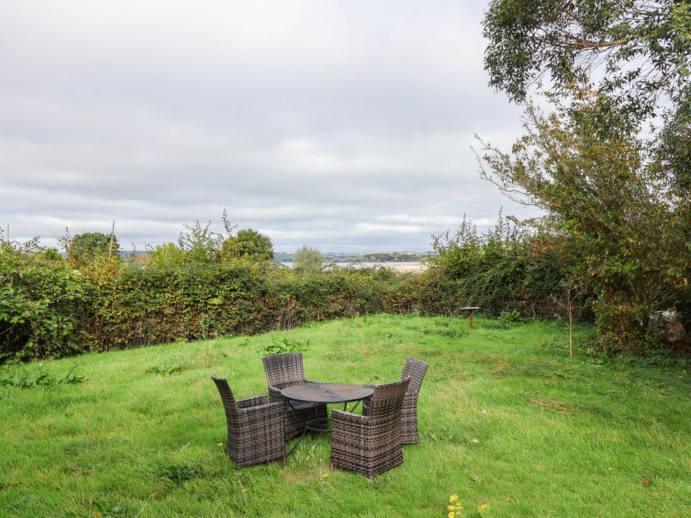 A garden with a table and chairs at Herriotts Bridge Cottage in Bristol