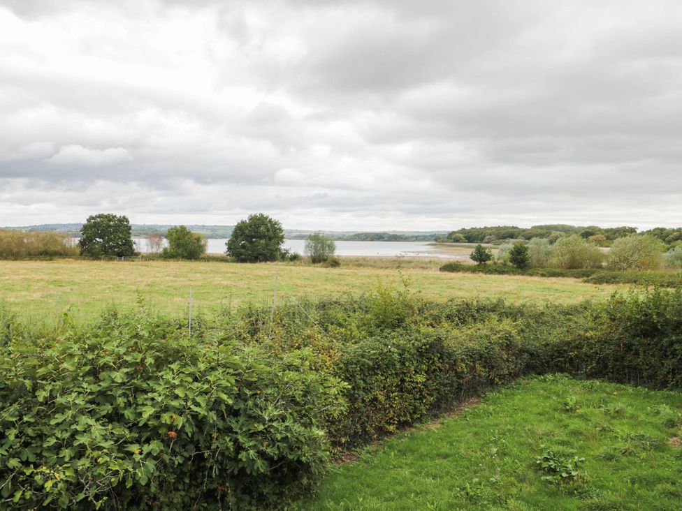 A view of a field and water at Herriotts Bridge Cottage in Bristol