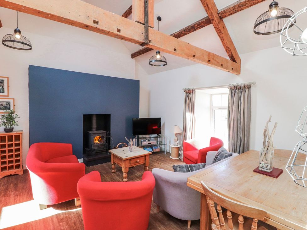 A living room with a sofa, chairs, and a fireplace at Hen Blas in Pwllheli