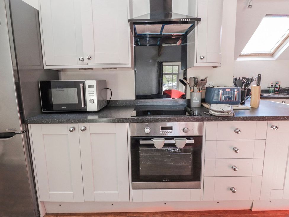 A kitchen with a microwave and an oven at Hen Blas in Pwllheli