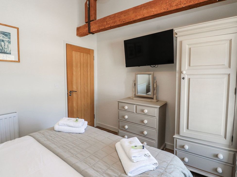 A bedroom with a bed and dresser at Hen Blas in Pwllheli