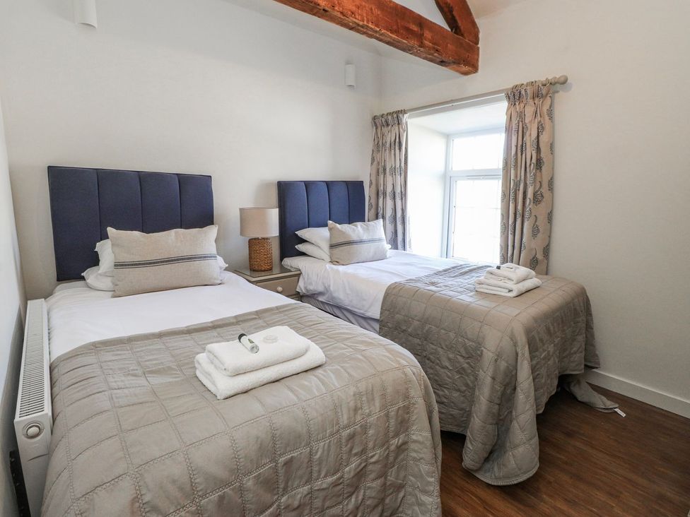 A bedroom with two beds and a window at Hen Blas in Pwllheli