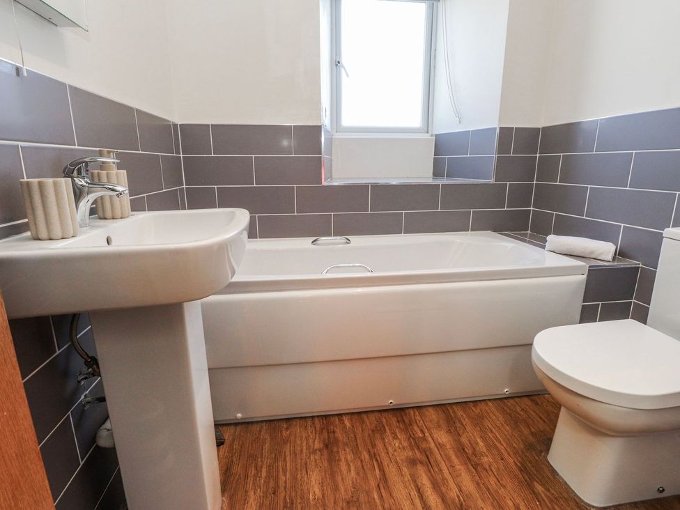 A bathroom with a bath tub and sink at Hen Blas in Pwllheli