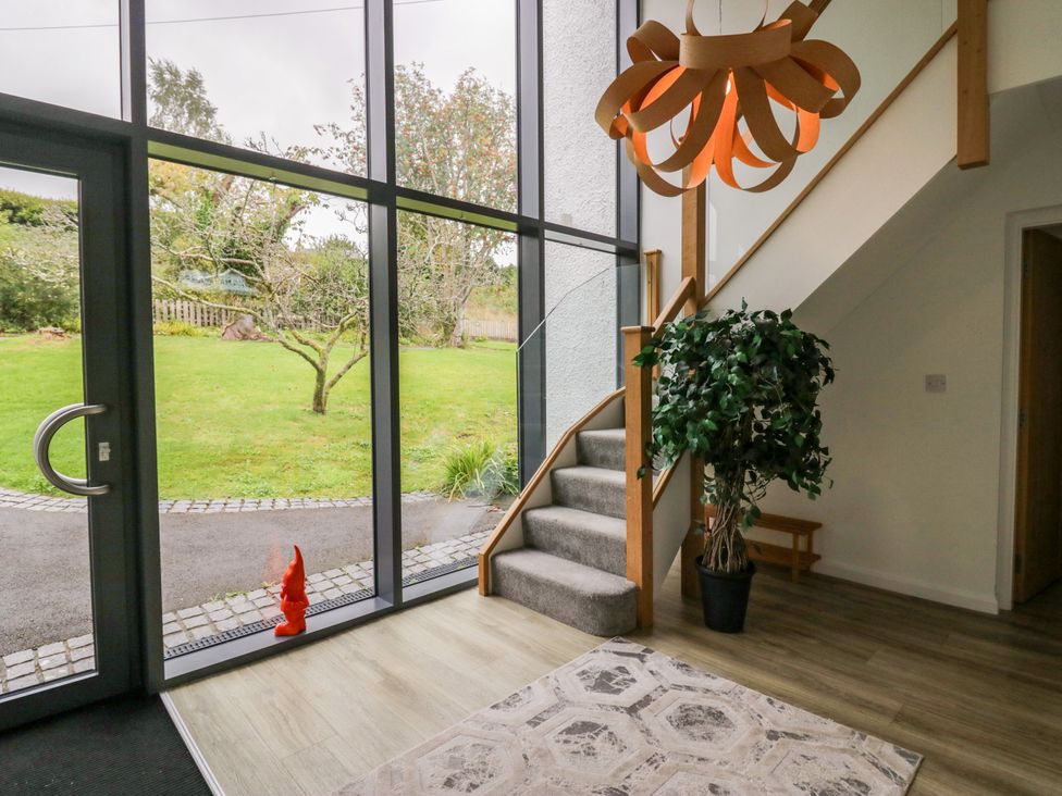 An entrance hall with a staircase and light fixture at 10 Rayrigg Rise in Bowness-On-Windermere