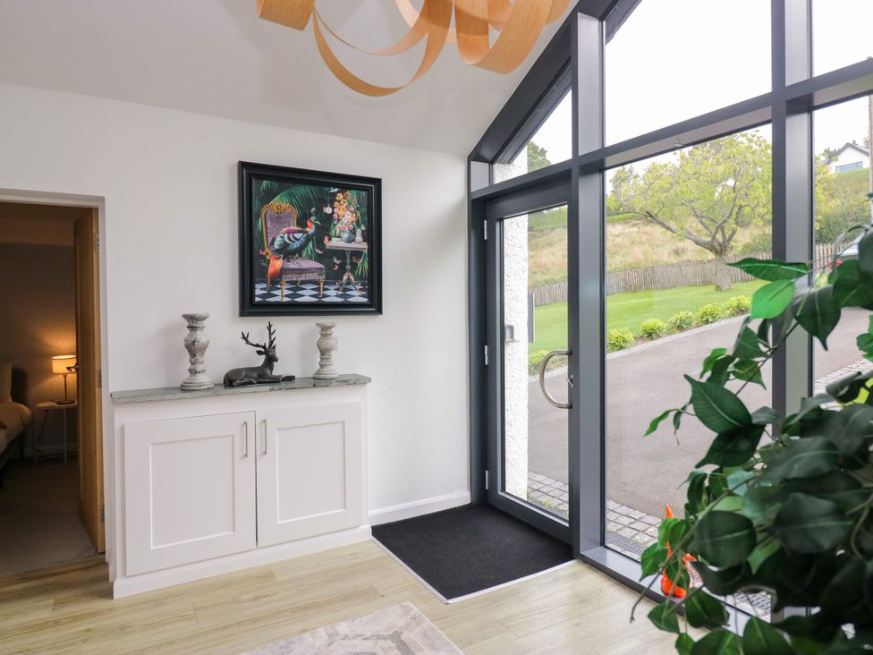 A hallway with a console table and artwork at 10 Rayrigg Rise Bowness-On-Windermere