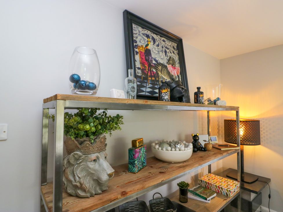 A shelf with decorative items and a lamp at 10 Rayrigg Rise Bowness-On-Windermere