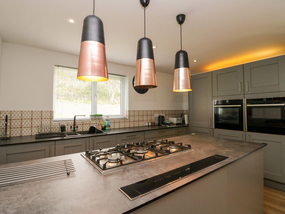 A kitchen with a gas stove and pendant lights at 10 Rayrigg Rise Bowness-On-Windermere