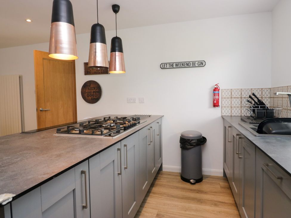 A kitchen with a cooker and cabinets at 10 Rayrigg Rise Bowness-On-Windermere