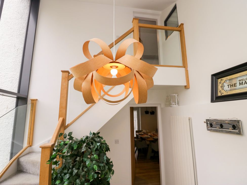 A staircase with a chandelier and potted plant at 10 Rayrigg Rise Bowness-On-Windermere