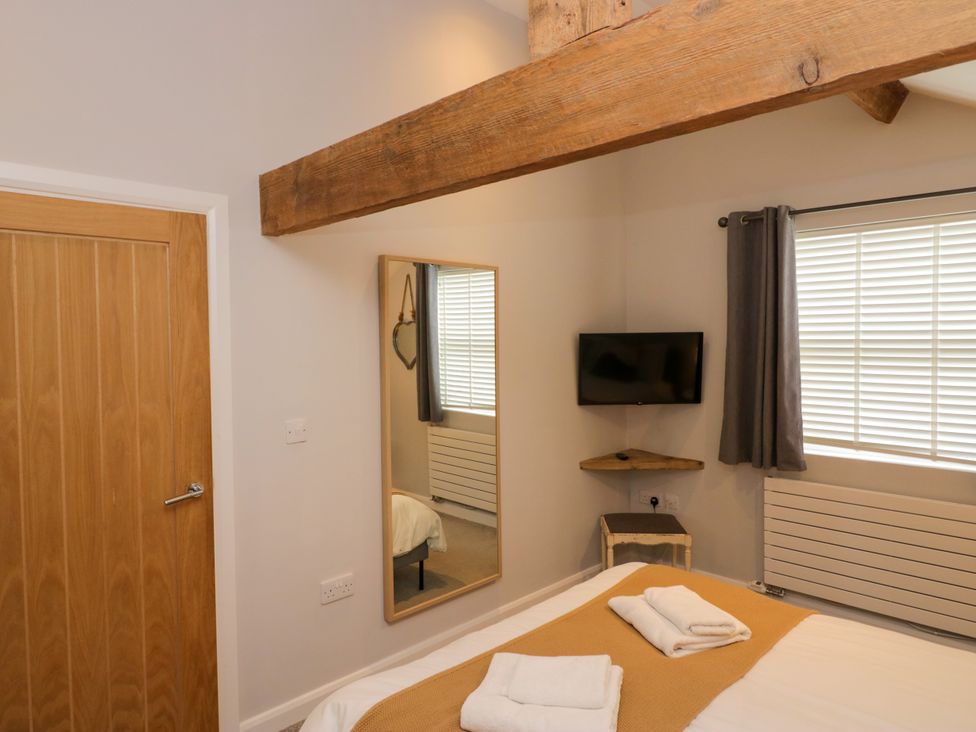 A bedroom with a bed and a mirror at 10 Rayrigg Rise Bowness-On-Windermere