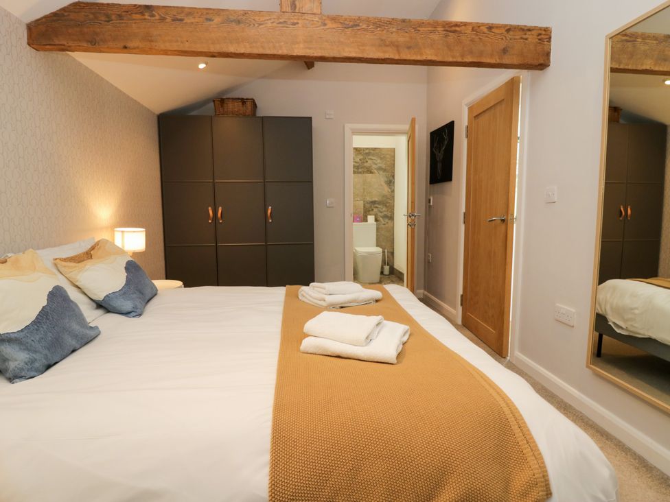 A bedroom featuring a bed with pillows and a wardrobe at 10 Rayrigg Rise Bowness-On-Windermere