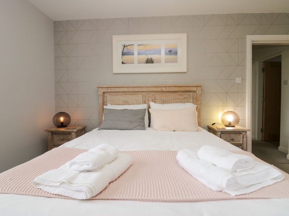 A bedroom with a bed and bedside tables at 10 Rayrigg Rise Bowness-On-Windermere