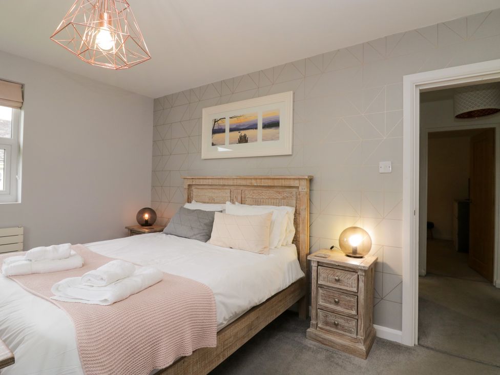 A bedroom with a bed and bedside tables at 10 Rayrigg Rise Bowness-On-Windermere