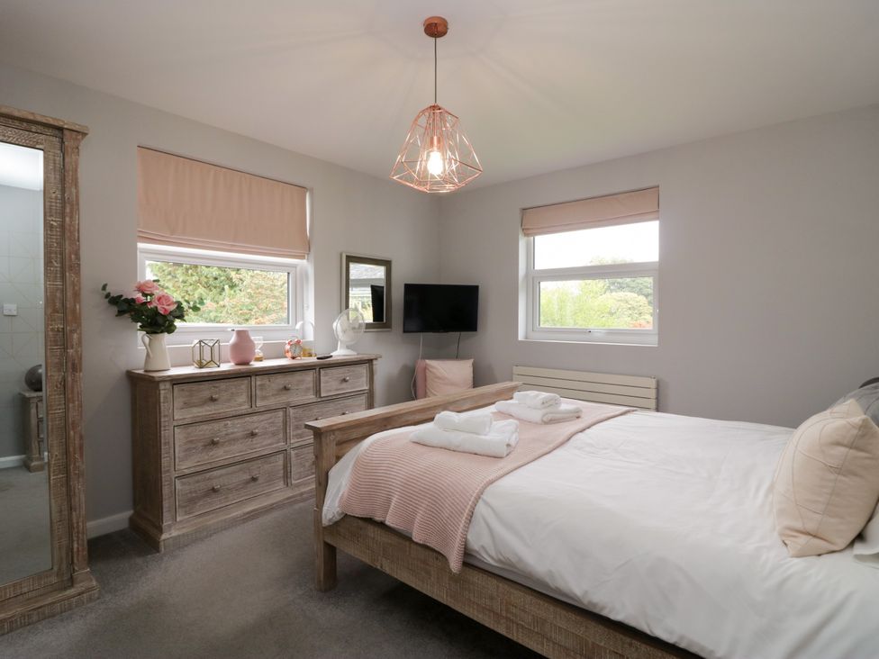 A bedroom with a bed and dresser at 10 Rayrigg Rise Bowness-On-Windermere