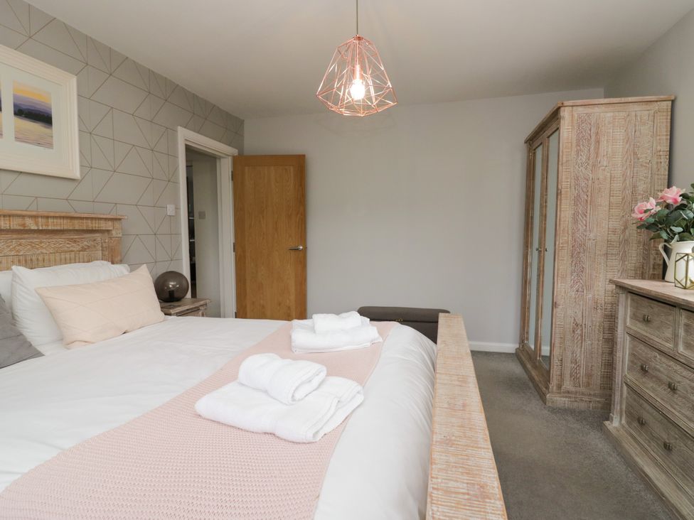 A bedroom with a bed and wardrobe at 10 Rayrigg Rise in Bowness-On-Windermere