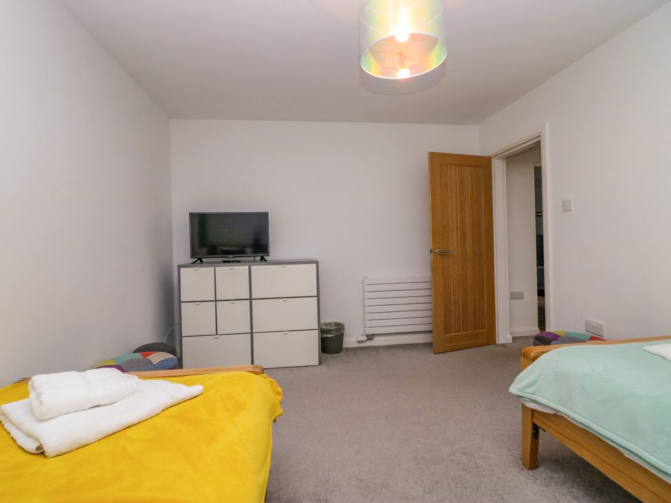 A bedroom with two beds and a television at 10 Rayrigg Rise Bowness-On-Windermere