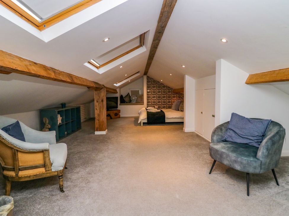 A loft with two armchairs and a bed at 10 Rayrigg Rise Bowness-On-Windermere