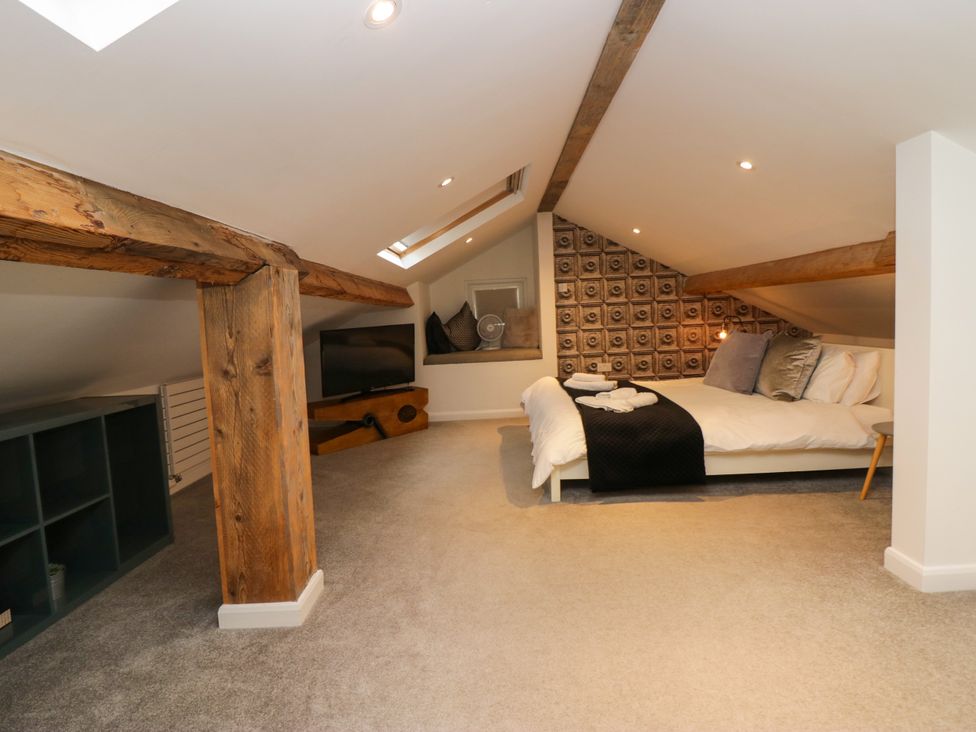 A loft bedroom with bed and television at 10 Rayrigg Rise Bowness-On-Windermere