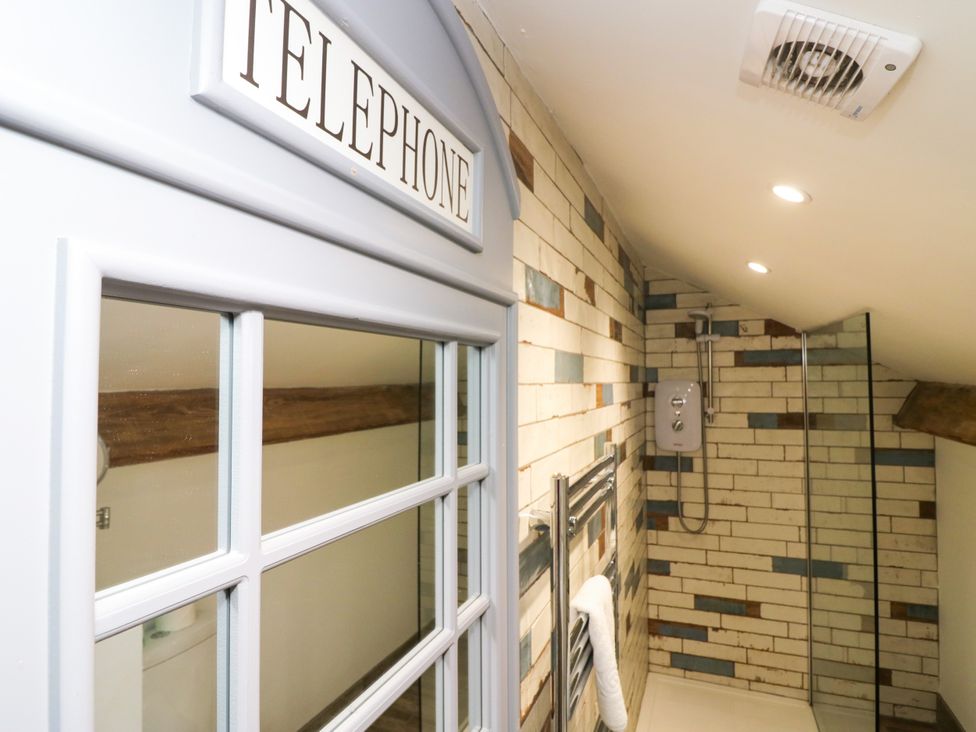 A bathroom with a shower and a telephone booth at 10 Rayrigg Rise Bowness-On-Windermere
