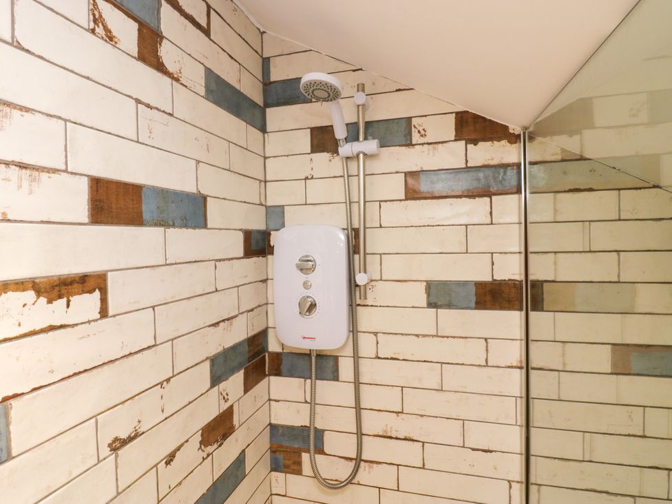A shower with tiles and control panel at 10 Rayrigg Rise Bowness-On-Windermere