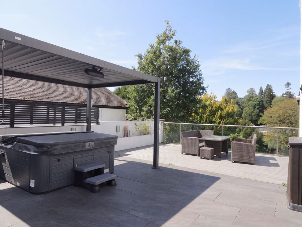 An outdoor area with a hot tub and seating at 10 Rayrigg Rise in Bowness-On-Windermere