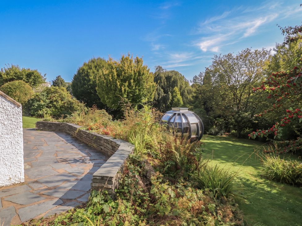 A patio and garden area with a glass structure at 10 Rayrigg Rise Bowness-On-Windermere