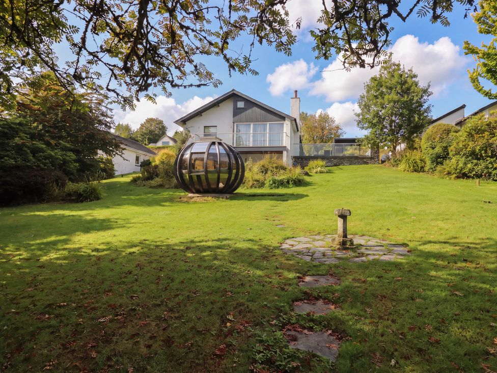 A garden with a house and ornamental structure at 10 Rayrigg Rise Bowness-On-Windermere