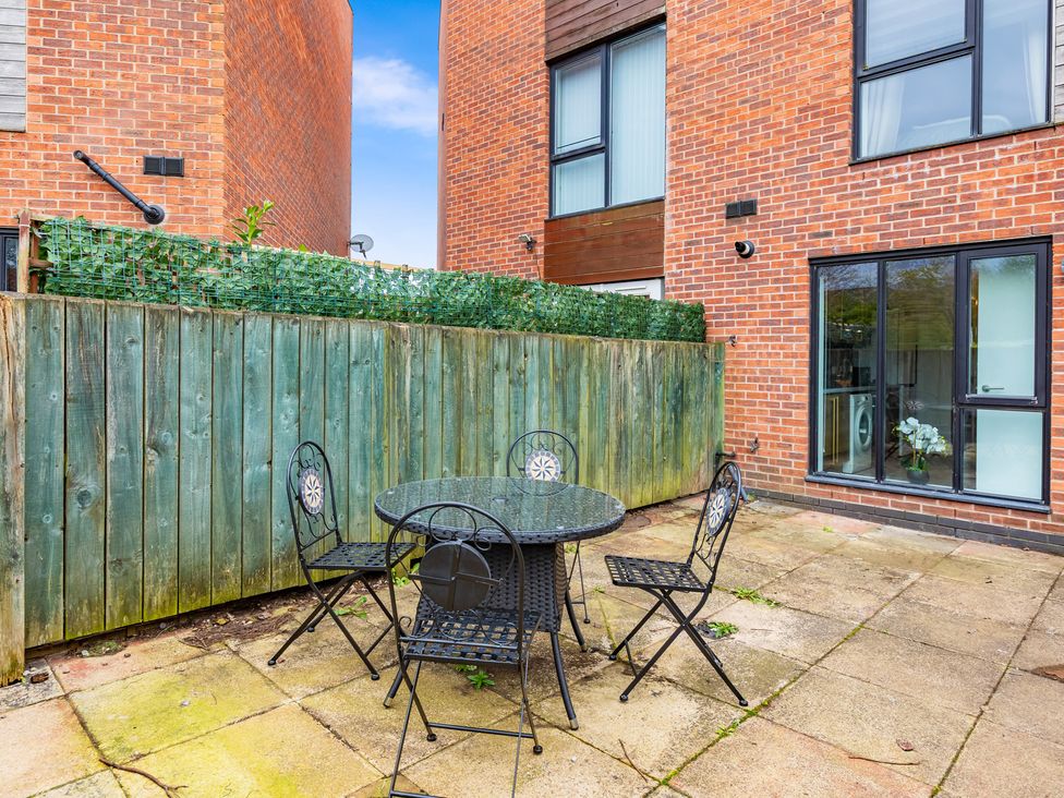 An outdoor seating area with a table and chairs at 11 Radclyffe Mews in Salford