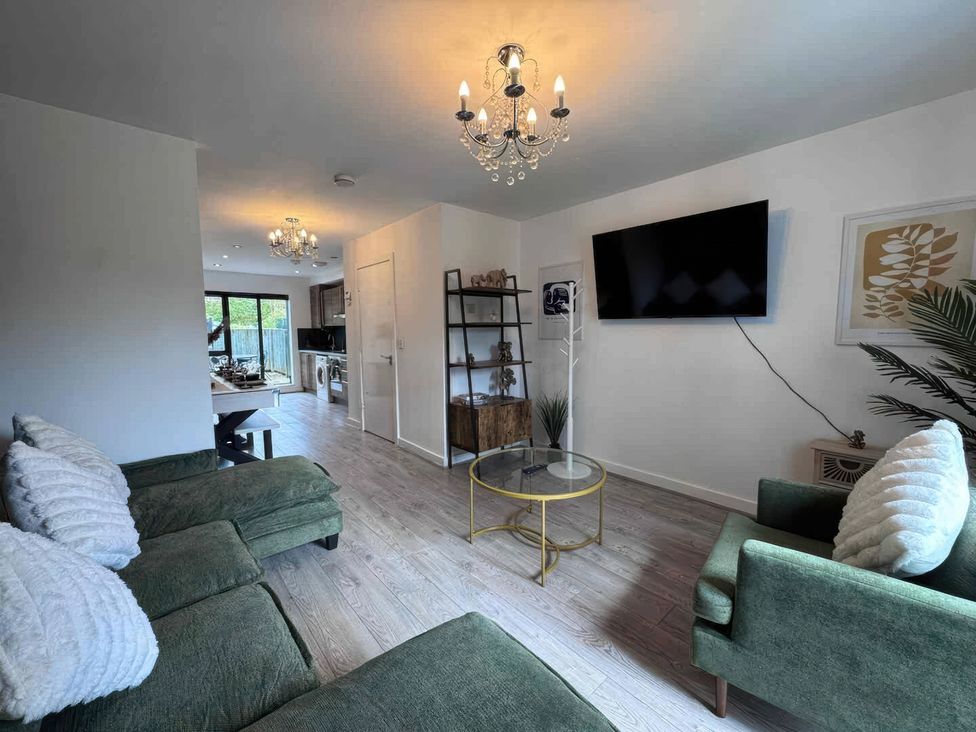 A living room with a sofa and TV at 11 Radclyffe Mews in Salford