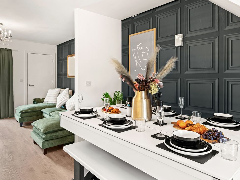 A dining room with a table set for a meal at 11 Radclyffe Mews in Salford