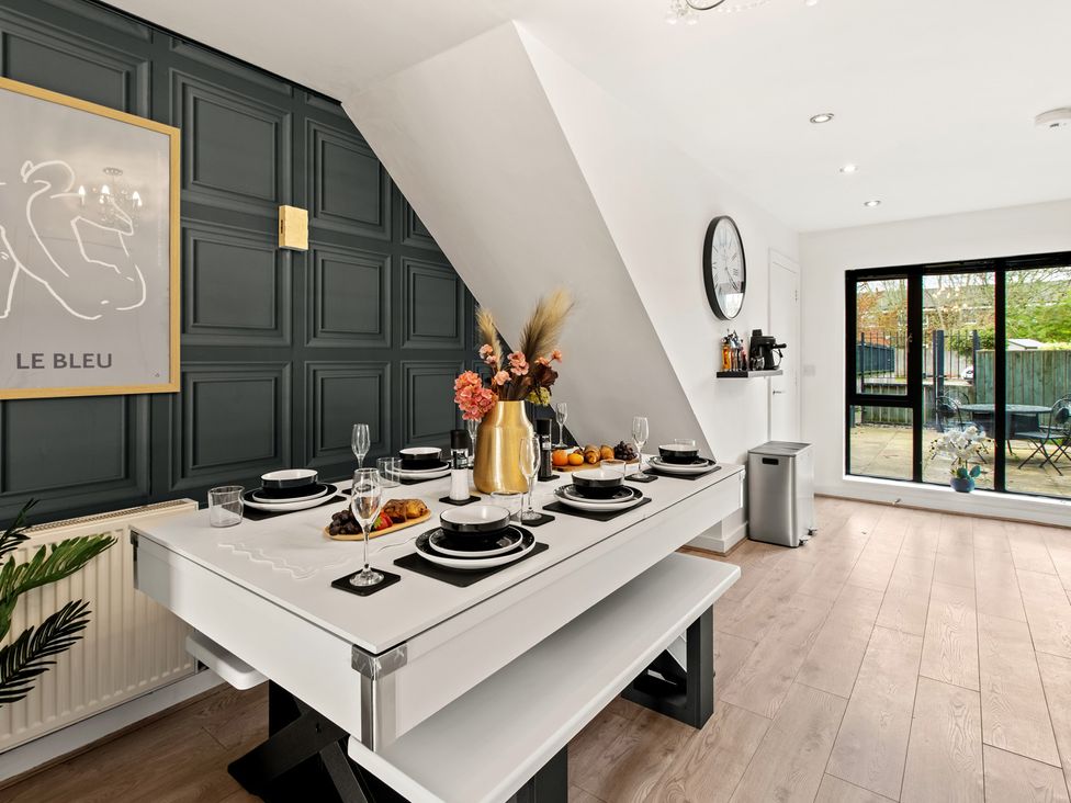 A dining room with a table set for a meal at 11 Radclyffe Mews in Salford
