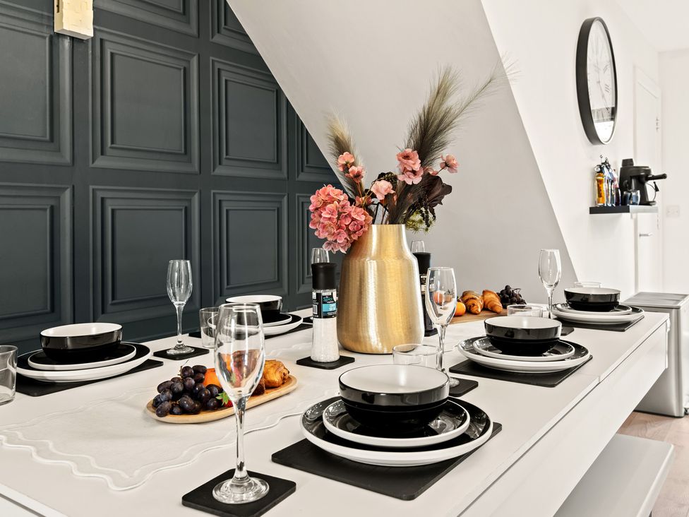 A dining table set with plates and glasses at 11 Radclyffe Mews Salford