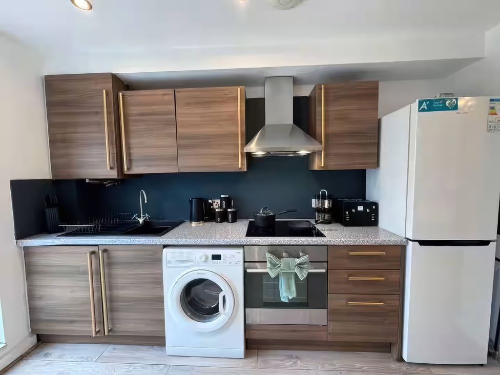 A kitchen with cabinets, stove, oven, and refrigerator at 11 Radclyffe Mews, Salford