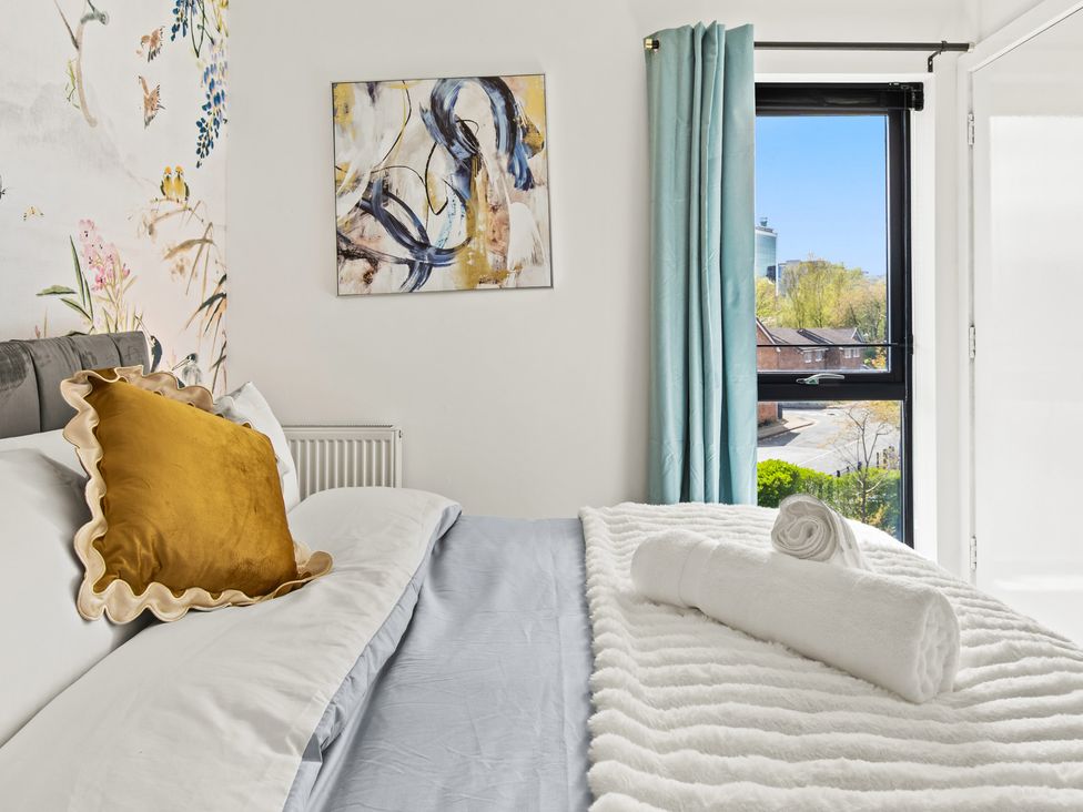 A bedroom with a bed and wall art at 11 Radclyffe Mews in Salford