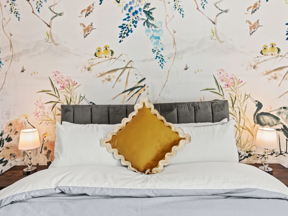 A bedroom with a bed and decorative pillows at 11 Radclyffe Mews, Salford
