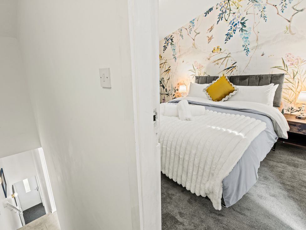 A bedroom with a bed and wallpaper at 11 Radclyffe Mews in Salford