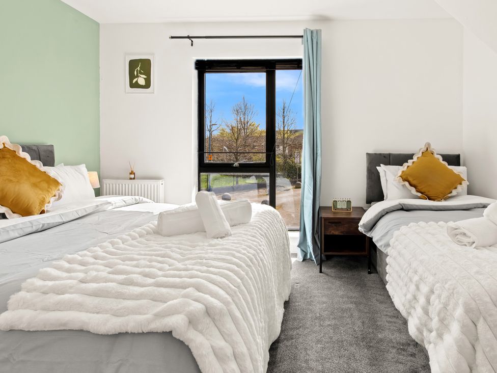 A bedroom with two beds and a window at 11 Radclyffe Mews in Salford