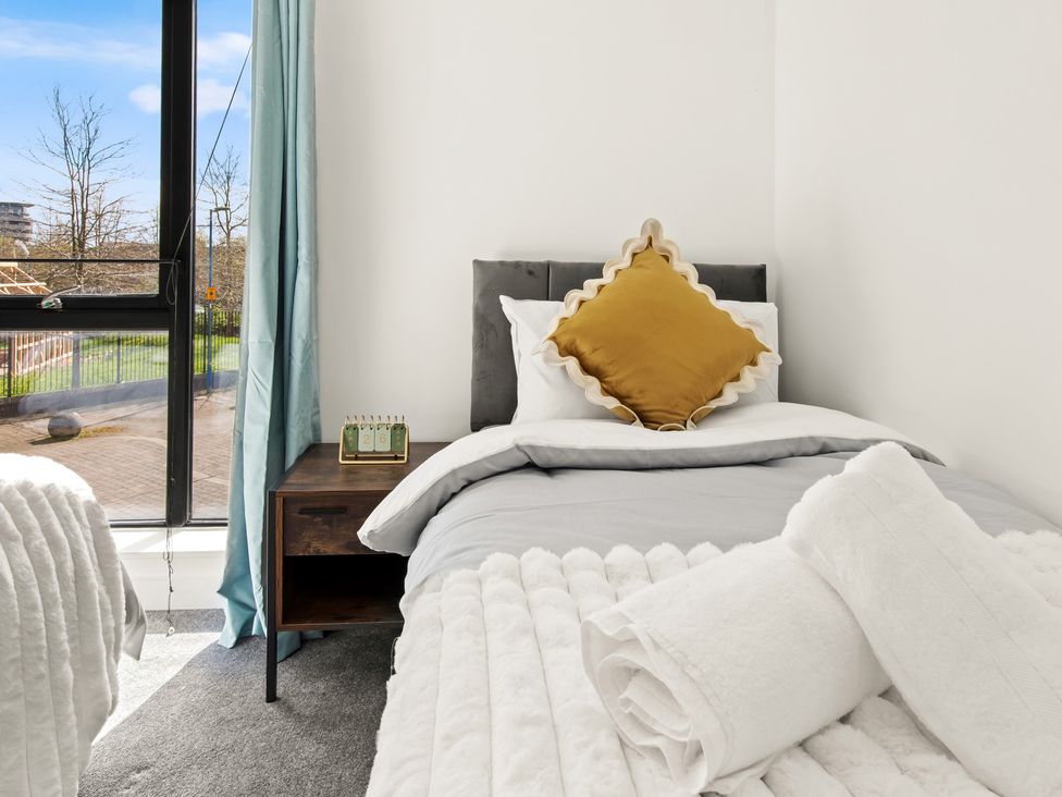 A bedroom with bed and nightstand at 11 Radclyffe Mews in Salford