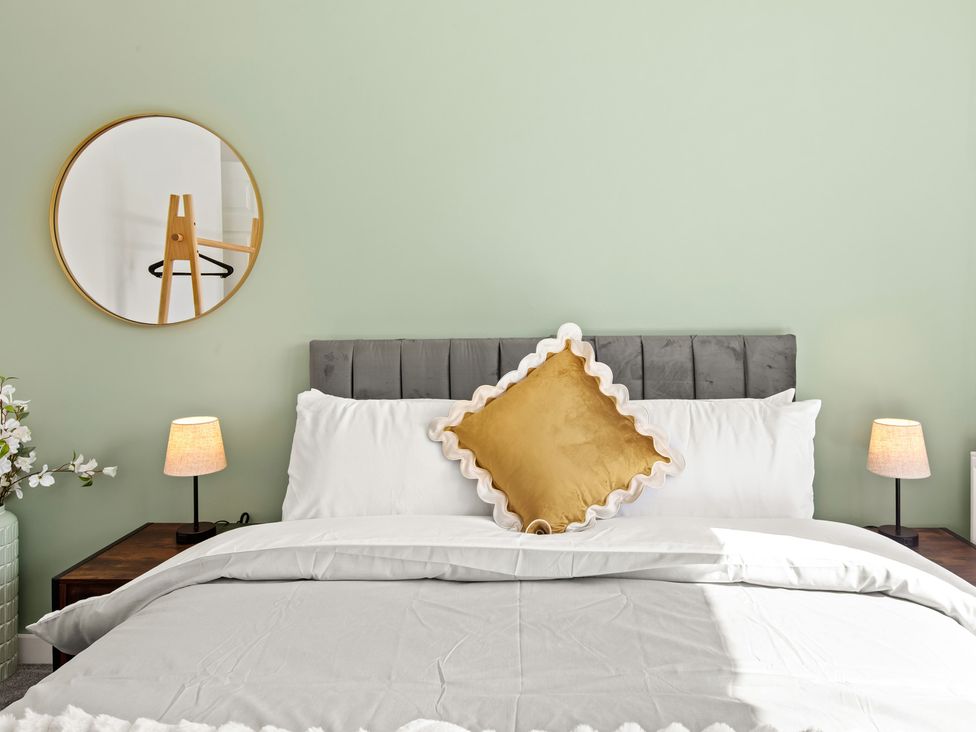 A bedroom with a bed and decorative pillows at 11 Radclyffe Mews in Salford