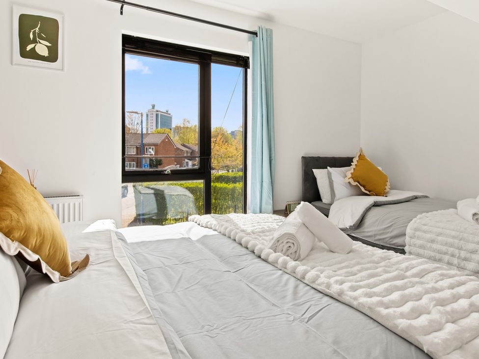 A bedroom with two beds and a view of the outdoors at 11 Radclyffe Mews Salford