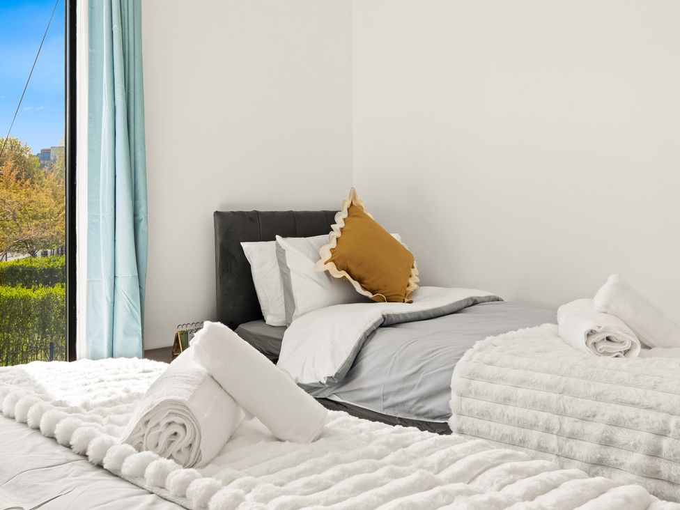 A bedroom with beds and towels at 11 Radclyffe Mews in Salford