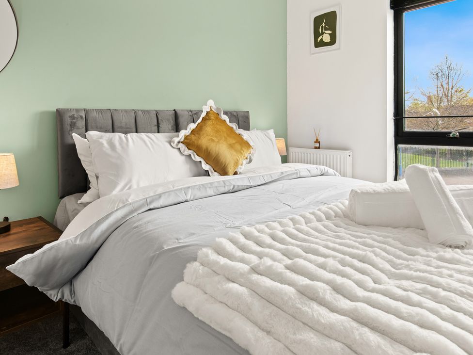 A bedroom with a bed and nightstand at 11 Radclyffe Mews in Salford