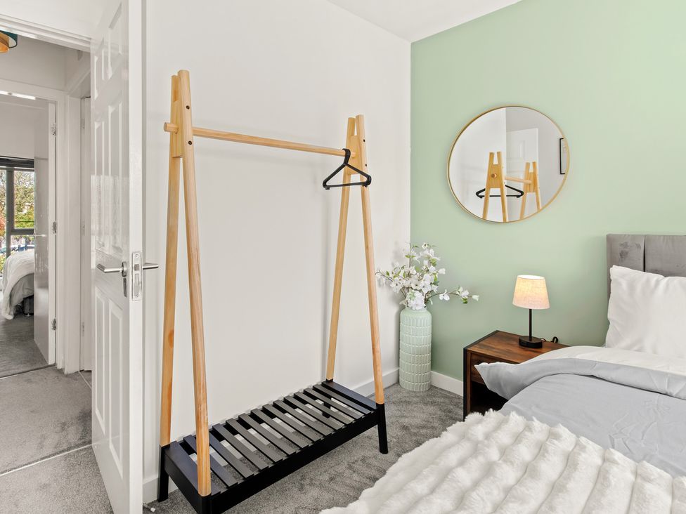 A bedroom with a bed, hanger, and lamp at 11 Radclyffe Mews in Salford