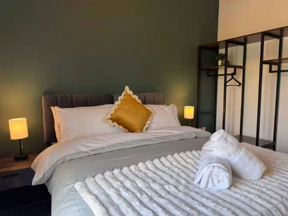 A bedroom with a bed and bedside lamps at 11 Radclyffe Mews Salford